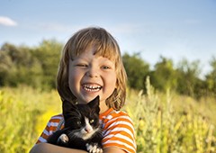 Happy child holding kitten|