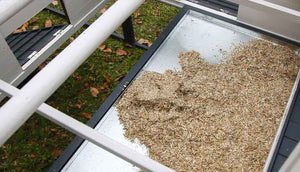 inside view of penthouse chicken coop with hemp bedding on pull out tray