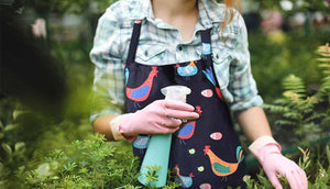 woman in outdoor garden wearing chicken apron